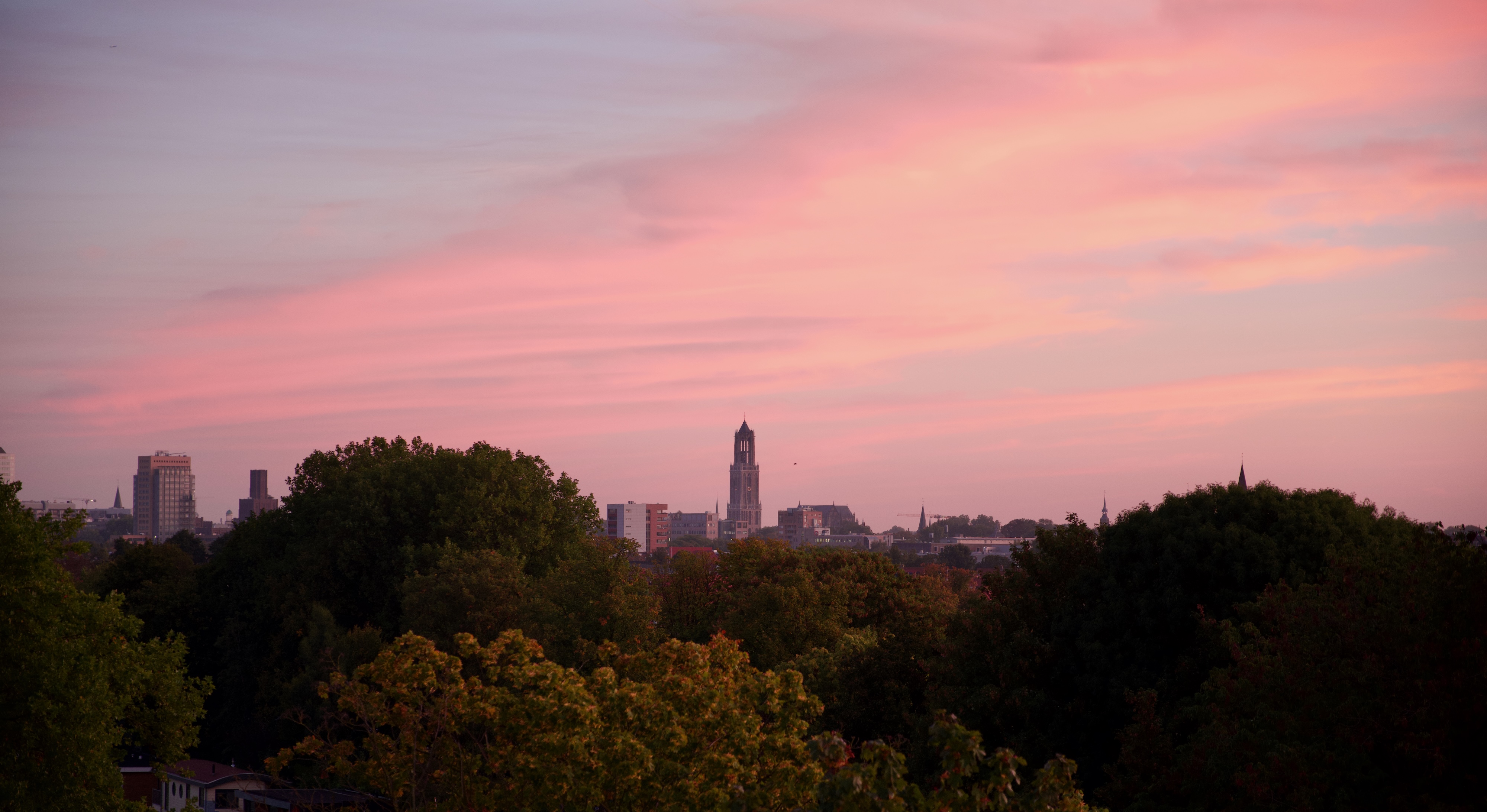 Utrecht at dusk, the Dom tower against a pink sky.